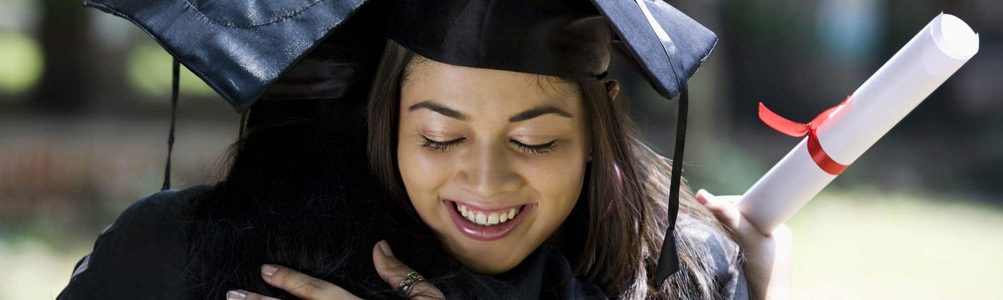 young woman hugging on graduation today, with graduation uniform and certificate in her hand